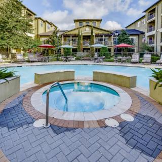 Luxurious outdoor area featuring a swimming pool and hot tub surrounded by resort-style accommodations.