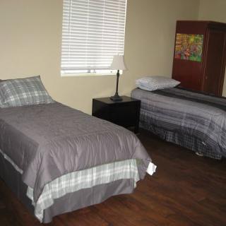 A simple bedroom with two twin beds and a nightstand.