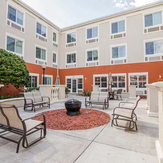 A well-furnished outdoor courtyard with a fire pit and seating arrangement.
