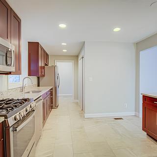 A modern kitchen with stainless steel appliances and recessed lighting.