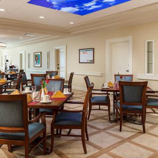A well-lit dining area with neatly arranged tables and chairs.