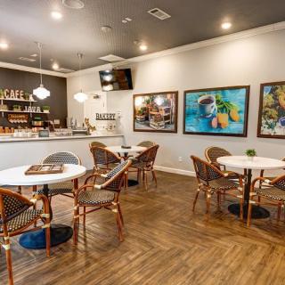 A cozy cafe interior with round tables and art-adorned walls.