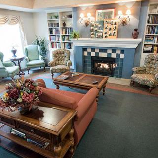 A cozy living room with a fireplace, bookshelves, and comfortable seating.