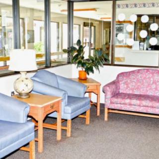 A lobby area with a seating arrangement consisting of blue chairs and a pink sofa.