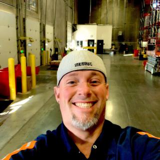 A person taking a selfie in a warehouse setting.
