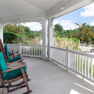 A tranquil porch with rocking chairs overlooking a scenic view.