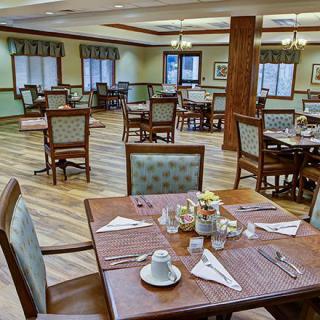 An empty dining room with neatly arranged tables and chairs, ready for service.