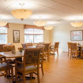 A well-lit dining area with wooden tables and chairs arranged neatly.