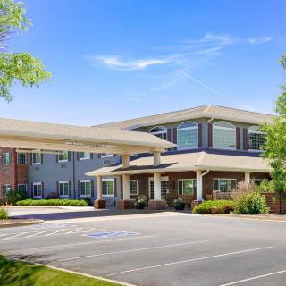A modern building with a welcoming entrance and an adjacent parking lot.