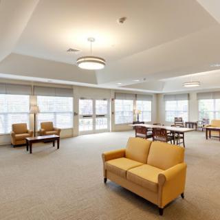 A spacious and modern lounge area featuring comfortable seating and ample natural light.
