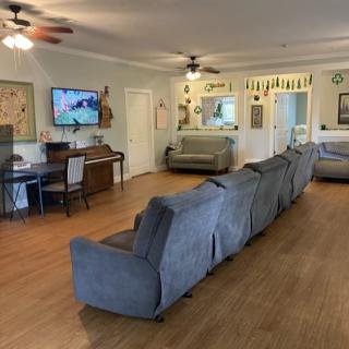 A spacious living room with multiple sofas, a television, and wooden flooring.