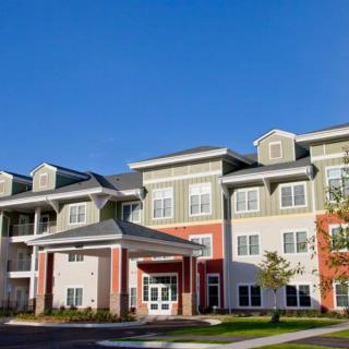 A modern residential apartment building under a clear blue sky.