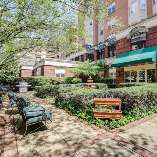 A peaceful urban courtyard with benches and lush greenery.