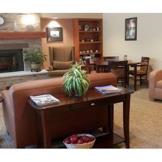 A cozy living room setup featuring a fireplace, comfortable seating, and a dining area.