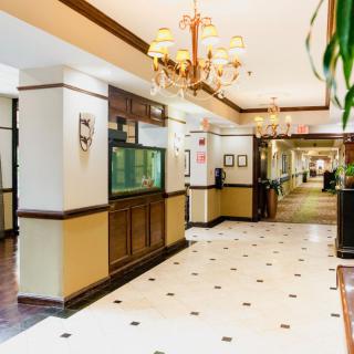A brightly lit hotel lobby with chandeliers and a tiled floor.