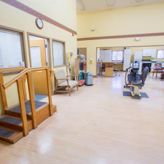 A spacious rehabilitation center featuring exercise equipment and a set of stairs for physical therapy sessions.