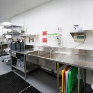 A well-organized commercial kitchen with stainless steel fixtures and multiple sinks.