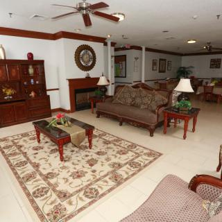 A cozy living room with comfortable sofas, a patterned rug, a fireplace, and elegant wooden furniture.