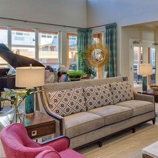 A cozy living room featuring a sofa, piano, and stylish decor.