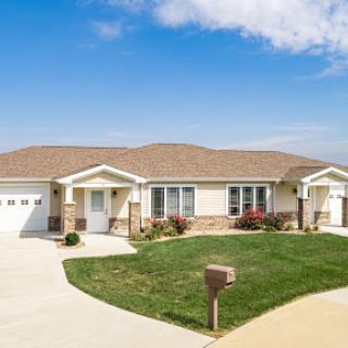 A beautiful suburban home with a well-maintained lawn and clear blue skies.