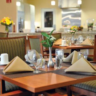A beautifully arranged dining area in a restaurant, featuring neatly folded napkins and floral decorations.