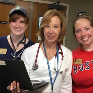 A team of healthcare professionals posing together in a hospital setting.