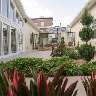 A well-maintained courtyard with lush plants and a seating area.