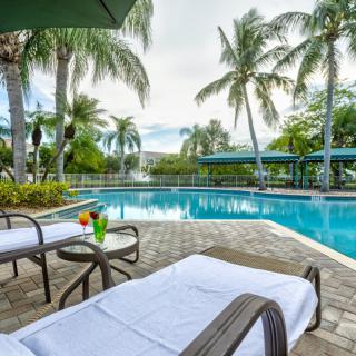 A serene poolside setting with loungers and palm trees, perfect for a tropical getaway.