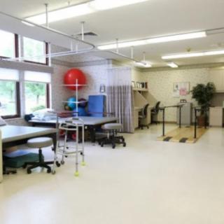 A spacious physical therapy room equipped with various rehabilitation tools and equipment.