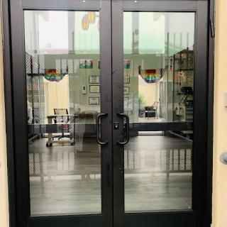 A set of stylish glass double doors leading into a contemporary interior space.