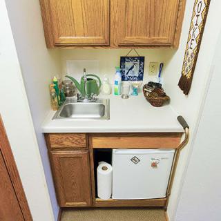 A compact kitchen area with a sink, cabinets, and countertop in a small space.