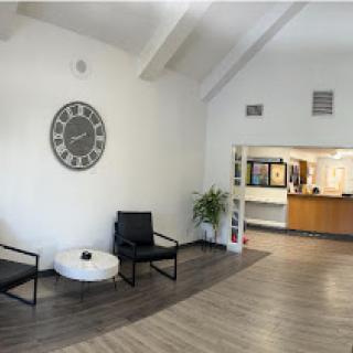 A modern waiting area featuring minimalistic furniture and a large wall clock.