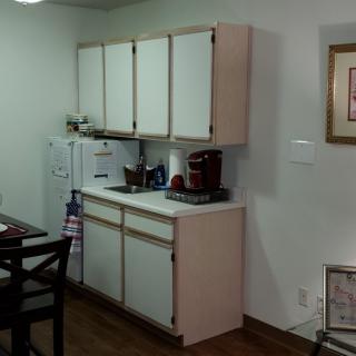 A cozy kitchen area with white cabinets and a countertop.
