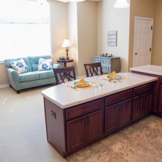 A cozy open-space kitchen with a central island and adjacent living area.
