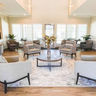 A modern, bright living room with multiple seating options and a central coffee table.