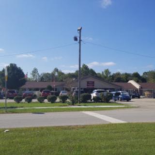 A clear day view of a building with a parking lot and power lines.