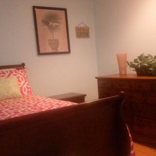 A cozy bedroom with a wooden bed, dresser, and decorative items.