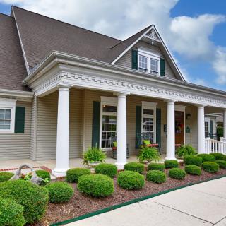 A beautiful residential home with a welcoming porch and well-maintained landscaping.