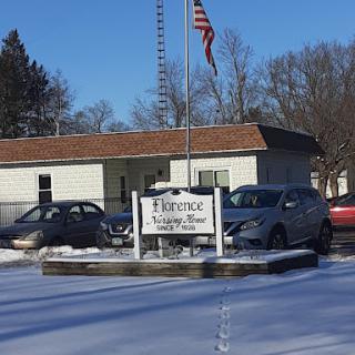 The entrance to a facility, marked by a sign and surrounded by snow.