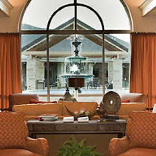 A cozy living room with elegant furnishings and a view of an outdoor fountain.
