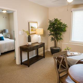 A cozy and well-decorated living area leading to a bedroom, featuring stylish furniture and decor elements.
