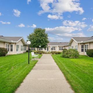 A well-maintained garden path leading to residential buildings under a clear blue sky.