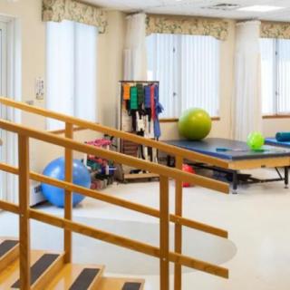 A physical therapy room with exercise equipment and a rehabilitation staircase.