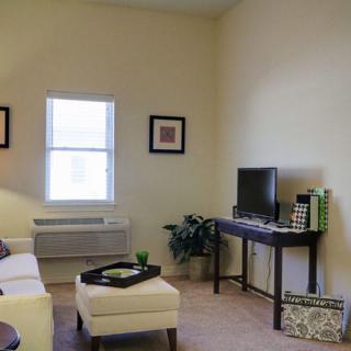 A cozy living room with minimalist decor, featuring a sofa and television.