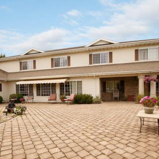 A spacious two-story residential house with a large patio area and outdoor seating.