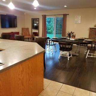 A spacious open-concept kitchen and dining area with wooden flooring and modern furnishings.