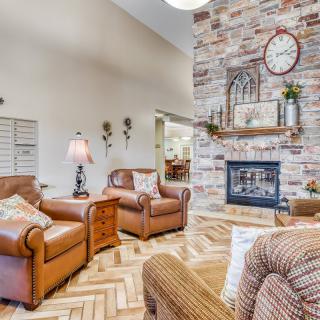 Cozy living room with leather chairs and a brick fireplace.