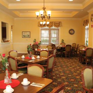 A cozy dining room with elegantly set tables, decorative lighting, and comfortable seating.