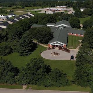 Aerial view of a building surrounded by lush greenery and outdoor areas.