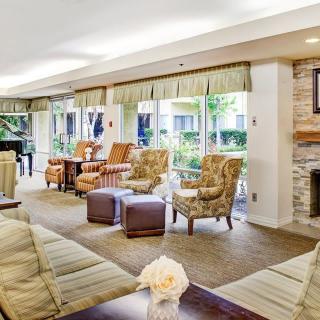 A cozy lounge area with comfortable seating, large windows, and a fireplace.
